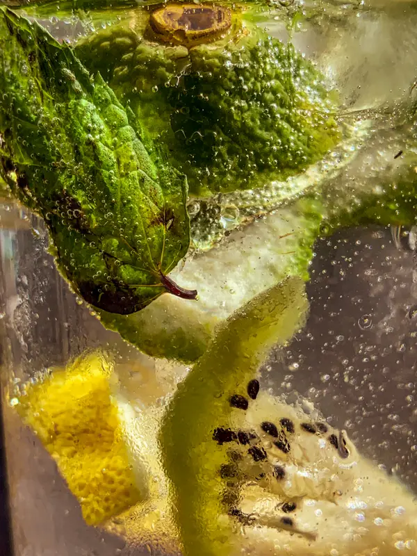 Macro close-up of mint leaves and kiwi inside a sparkling drink — Aziz Stiti detail photography