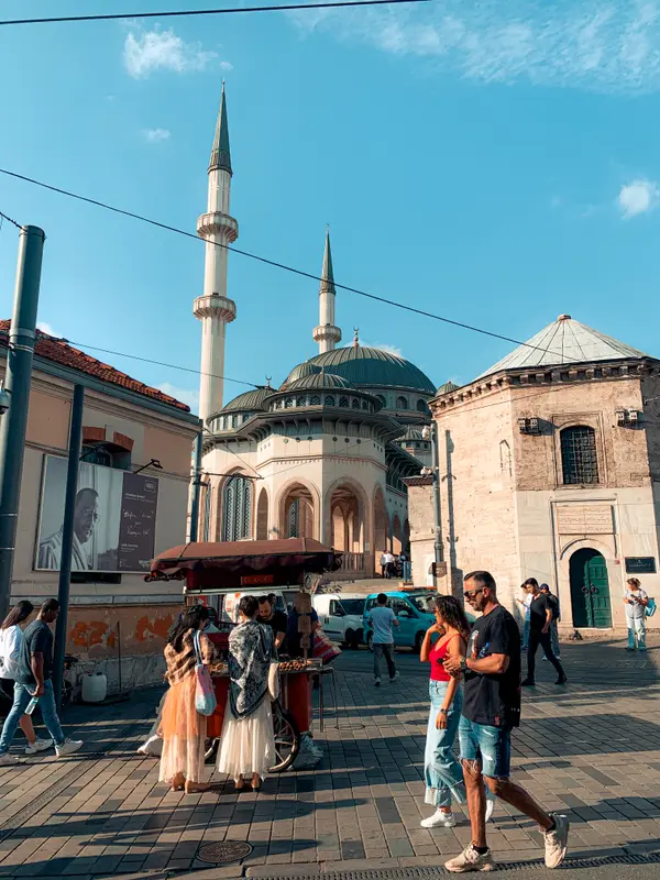 Couple posing in front of Taksim Mosque in Istanbul with street food cart — Aziz Stiti travel photography
