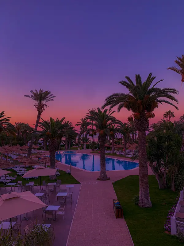 Sunset over the pool and palm trees at a Tunisian resort — Aziz Stiti photography