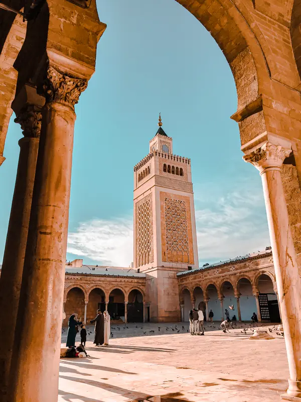Zitouna Mosque minaret seen through stone arches in Tunis Medina — Aziz Stiti travel photography